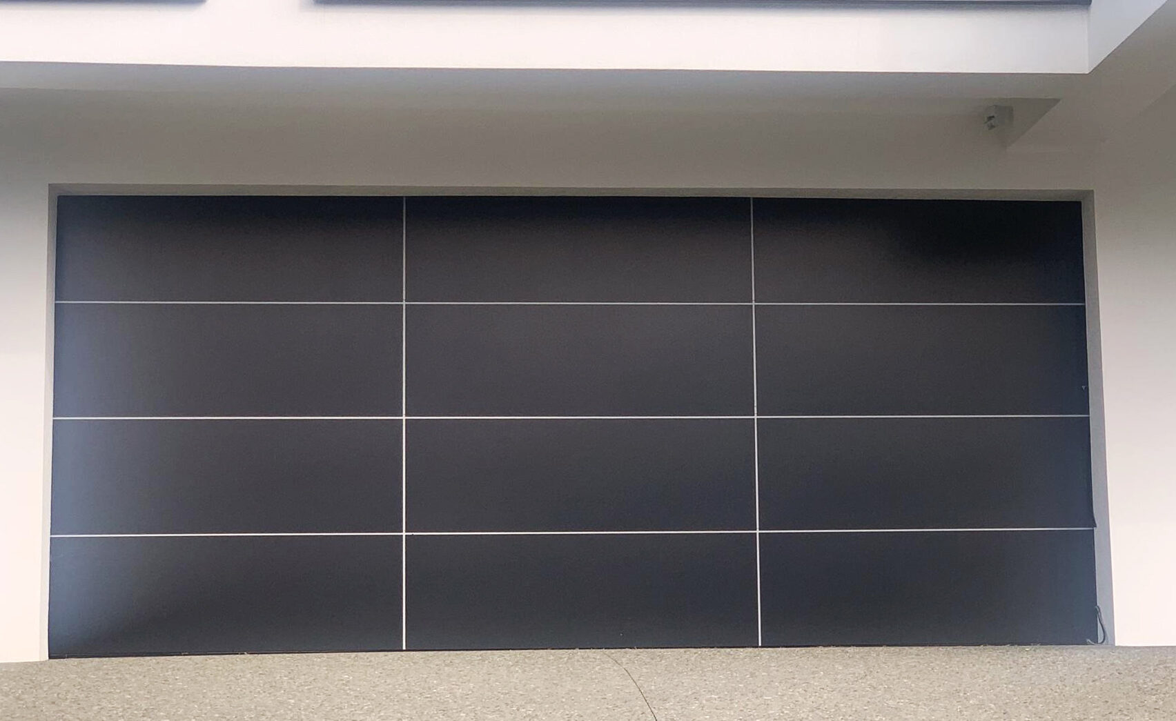 Aluminium composite sectional garage door on a coastal Auckland property